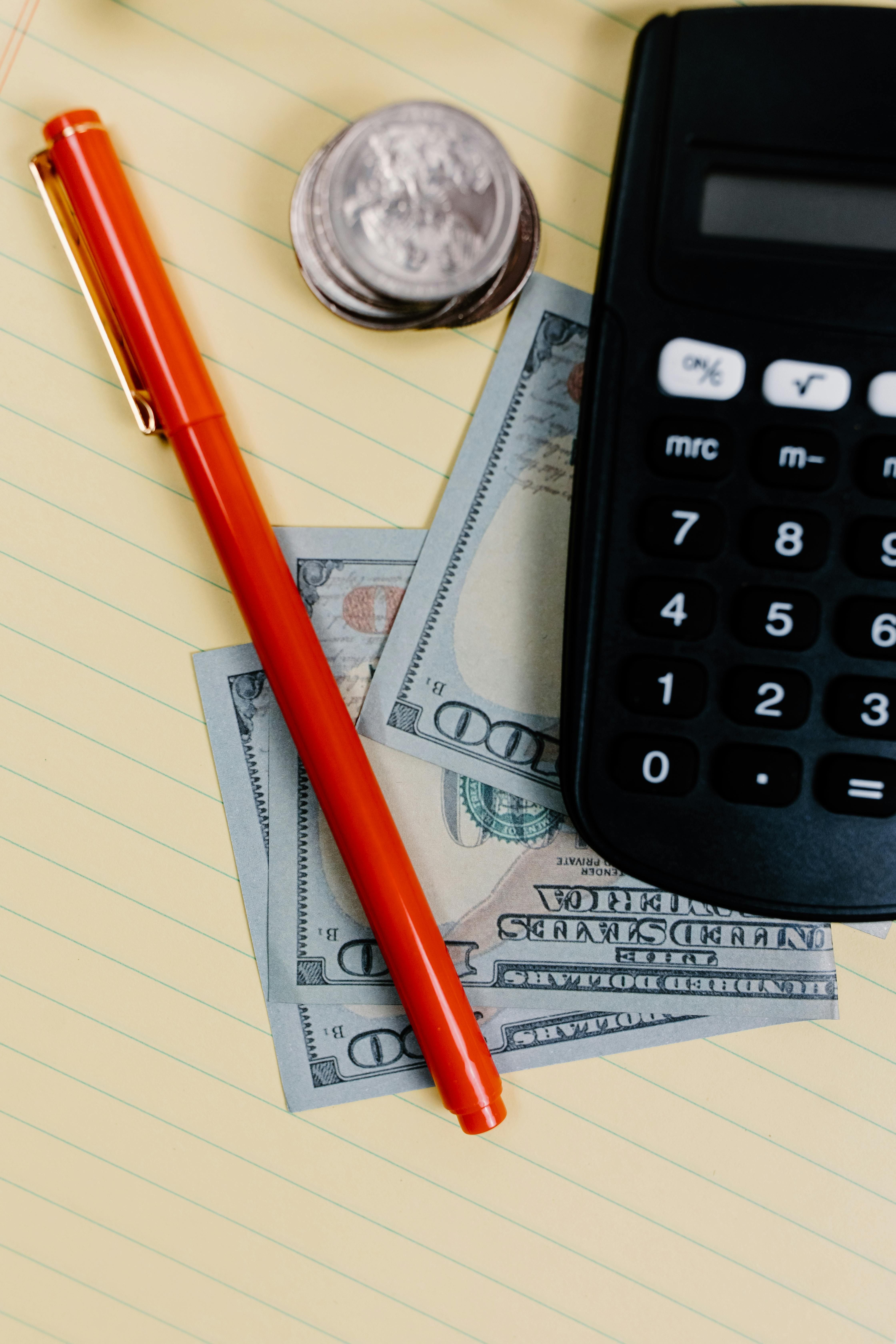 Calculadora y dinero para ilustrar cuentas nómina y bonificaciones